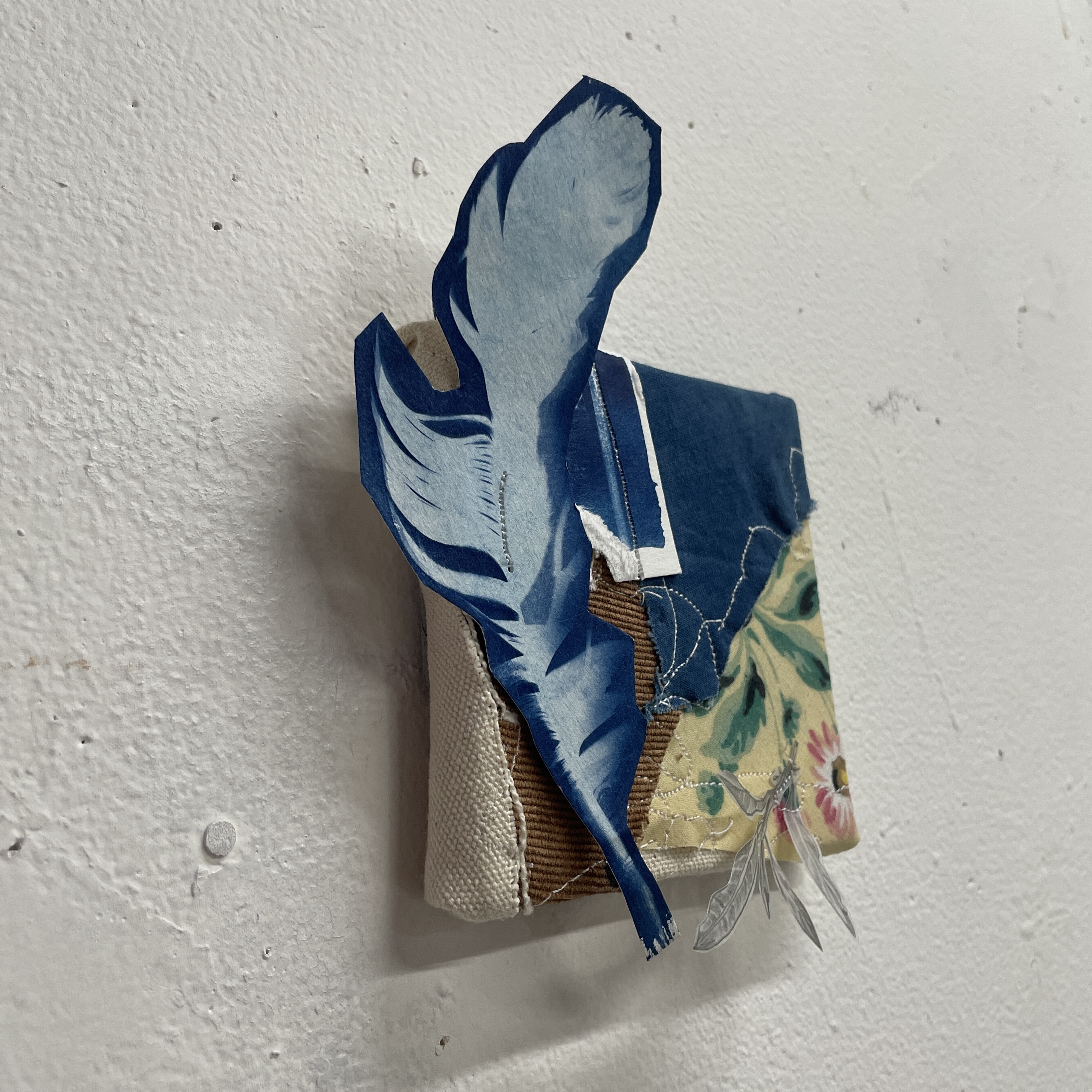 Cyanotype feather collage on stitched fabric