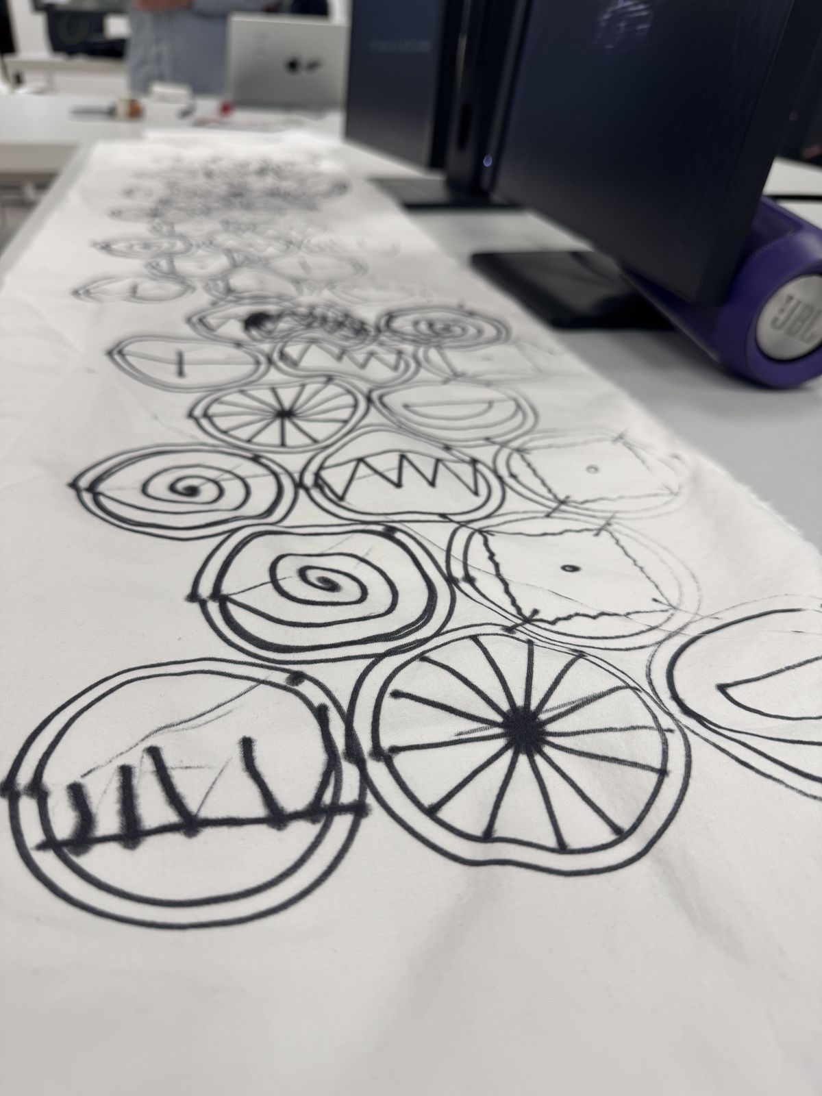Close-up of the cloth: overlapping spirals, wheels and zigzags in black pen